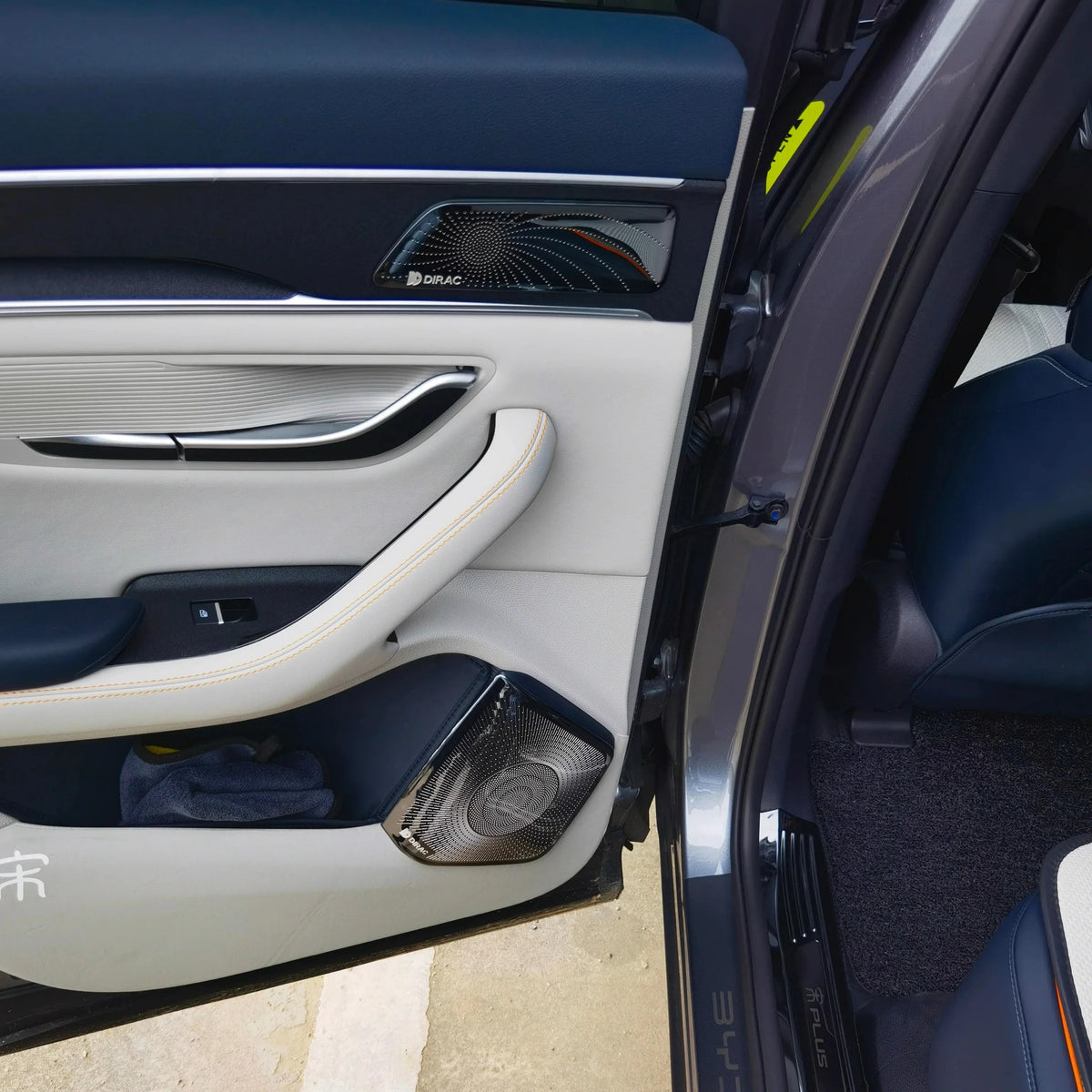 Premium white and navy blue BYD door panel featuring high-quality leather textures and Dirac speaker grilles.
