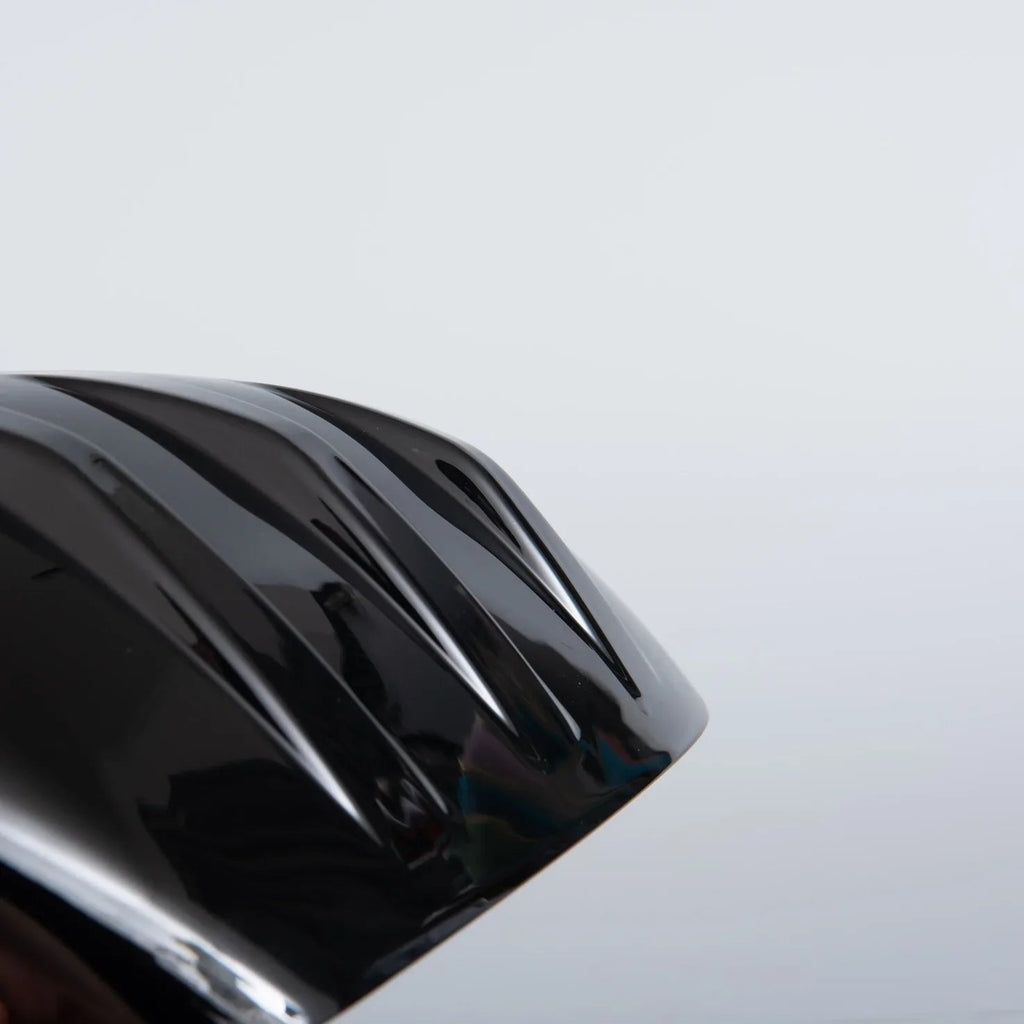 Close-up of a glossy black automotive accessory featuring a sleek, contoured design.