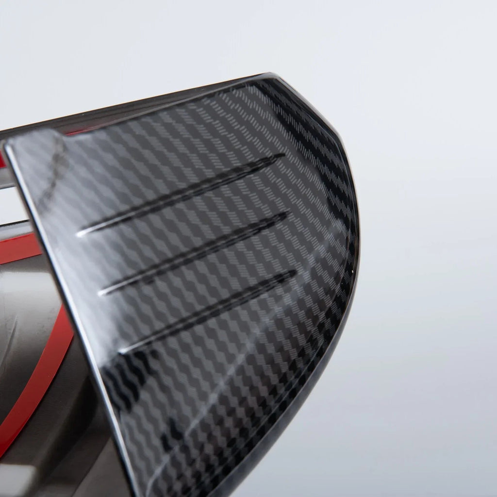 Close-up of a sleek grey carbon fiber automotive accessory with a textured weave finish.