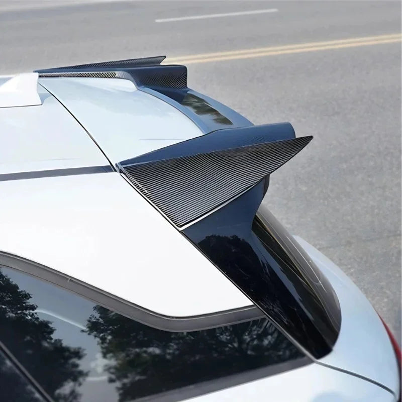 Glossy black carbon fiber rear spoiler wing installed on a white car