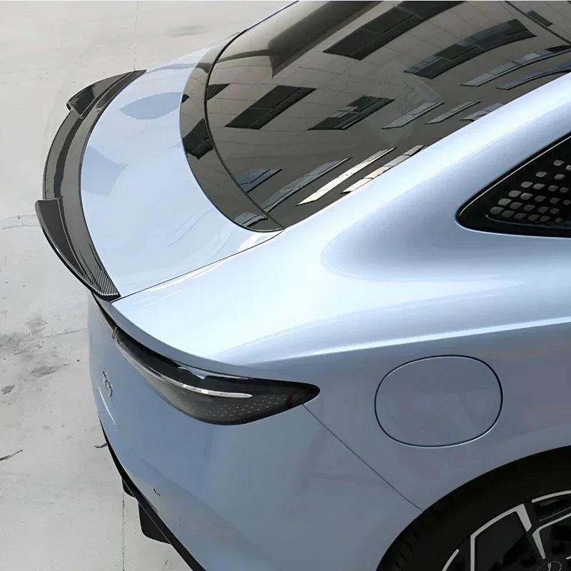 Carbon fiber rear spoiler installed on a light blue BYD car for enhanced aerodynamics.