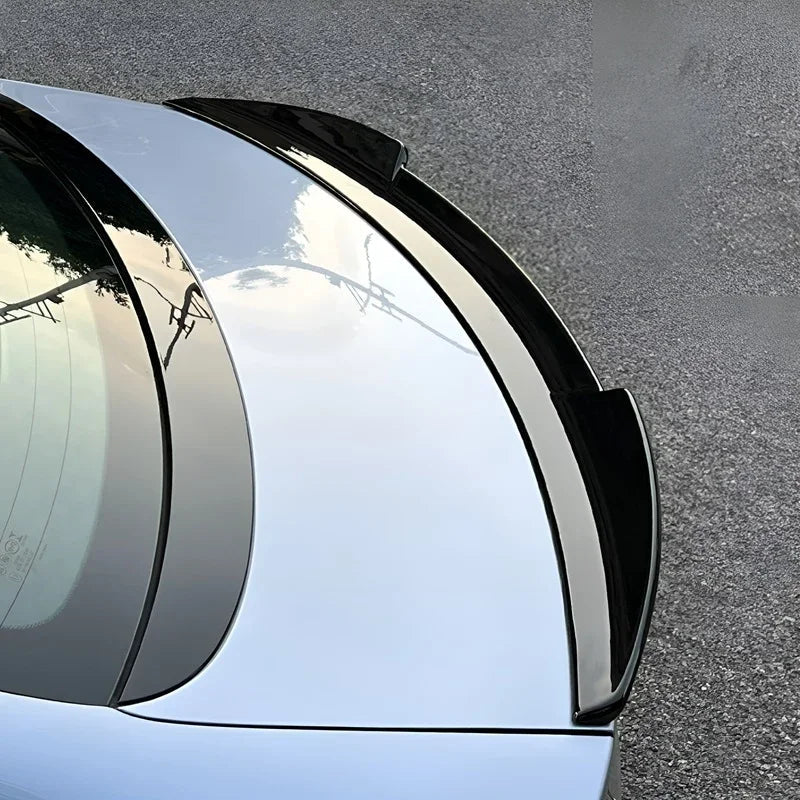 Glossy black aerodynamic rear spoiler installed on a silver BYD car trunk.