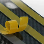 Flexible gold-colored adhesive tape strip with a carbon fiber texture pattern.