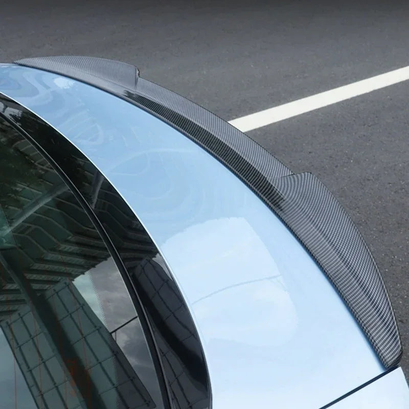 Carbon fiber rear spoiler installed on a light blue BYD car.