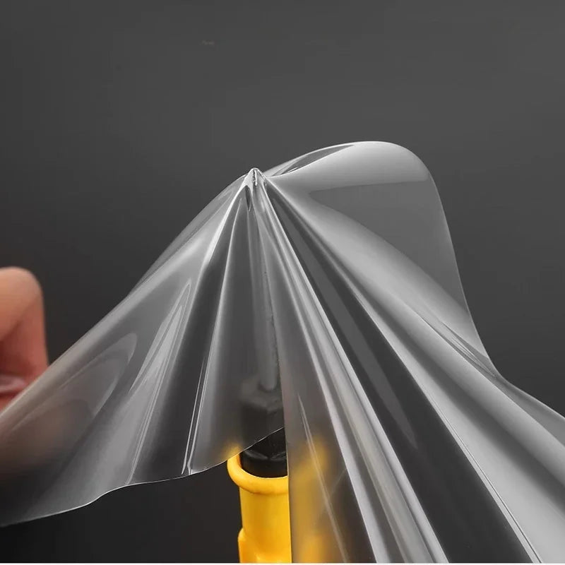Transparent protective film being applied to a yellow component, featuring a smooth and clear finish.