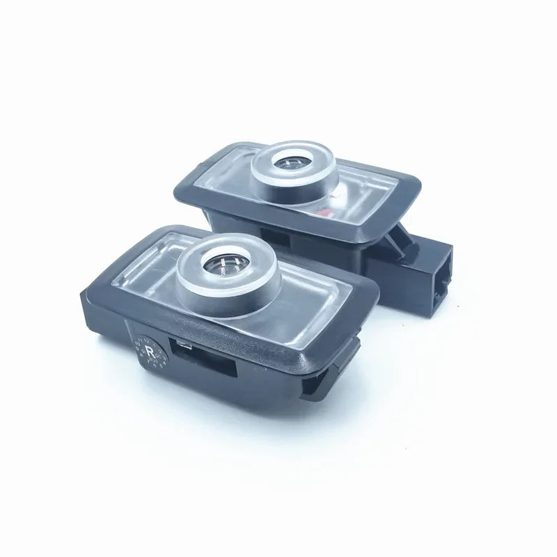 Pair of black rear-view parking sensor cameras with silver metallic lens housings.