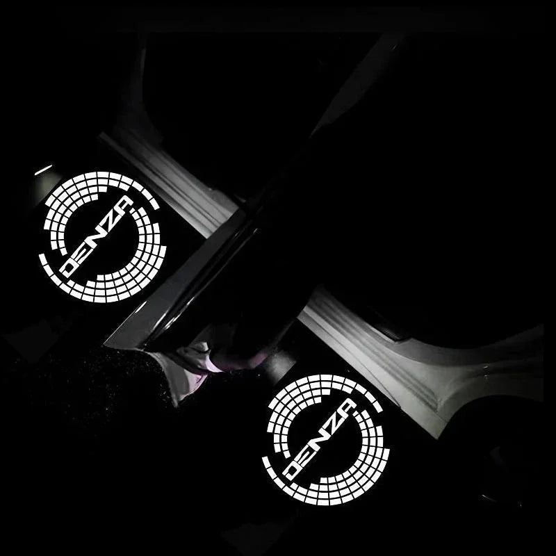 Glowing white DENZA logo welcome light projections on a dark car floor mat.
