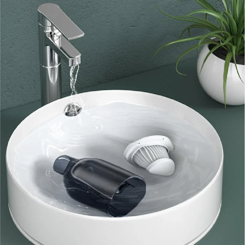 White ceramic vessel sink with a chrome faucet and a black bottle floating in water.