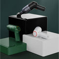 Set of three portable handheld car vacuum cleaners in black, forest green, and white matte finishes.