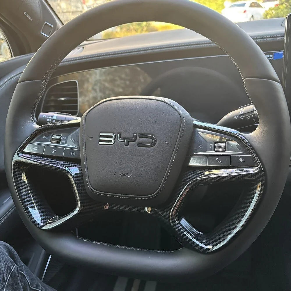 Black leather steering wheel with carbon fiber trim and BYD logo for BYD car interior.