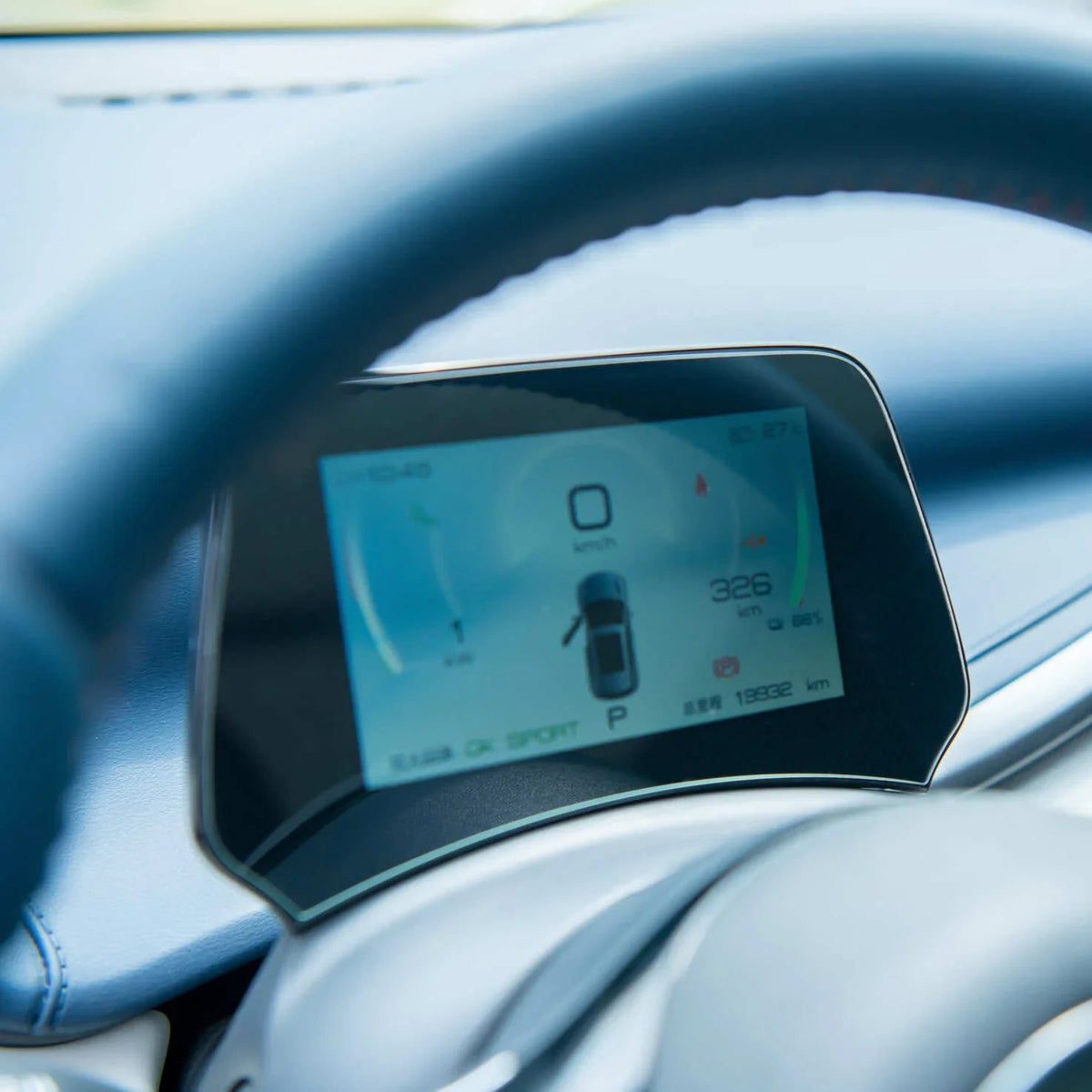 Digital blue car dashboard display showing speed, range, and vehicle status on a modern instrument cluster.