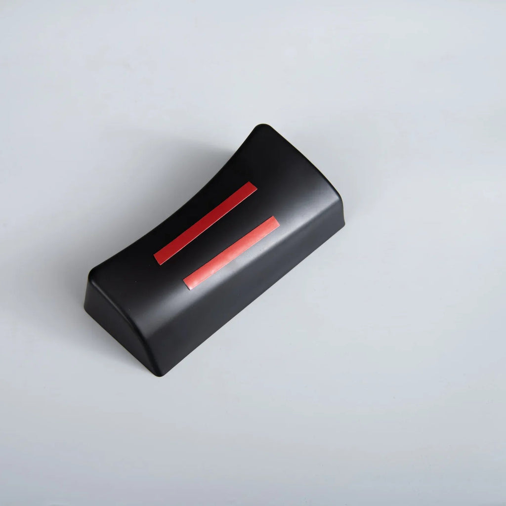 Black rectangular car accessory with two parallel red stripes on a plain grey background