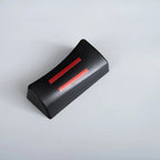 Black rectangular car accessory with two parallel red stripes on a plain grey background