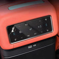 Orange leather car center console with a black digital climate control touch panel.