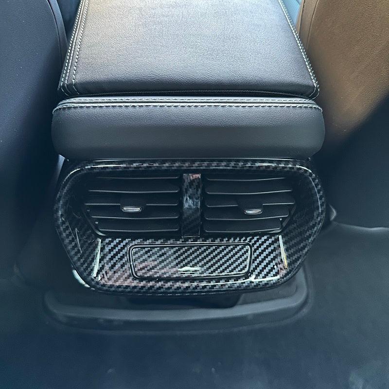 Glossy black carbon fiber pattern rear air vent trim for BYD vehicle interior.