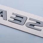 Close-up of custom gray laser-cut lettering on a durable textured light gray material.
