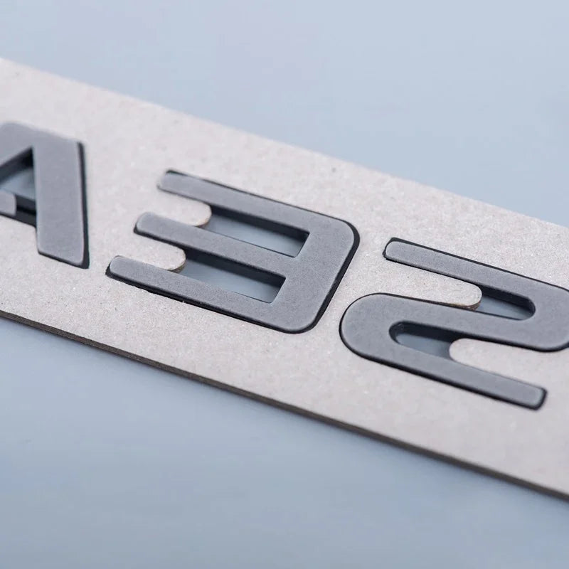 Close-up of custom gray laser-cut lettering on a durable textured light gray material.