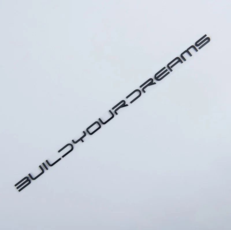 Black metallic decal sticker with the text BUILDYOURDREAMS in a modern font on a white background.