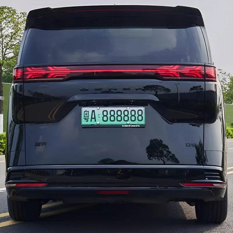 Rear view of a sleek black Denza D9 luxury MPV featuring a continuous red LED light bar.