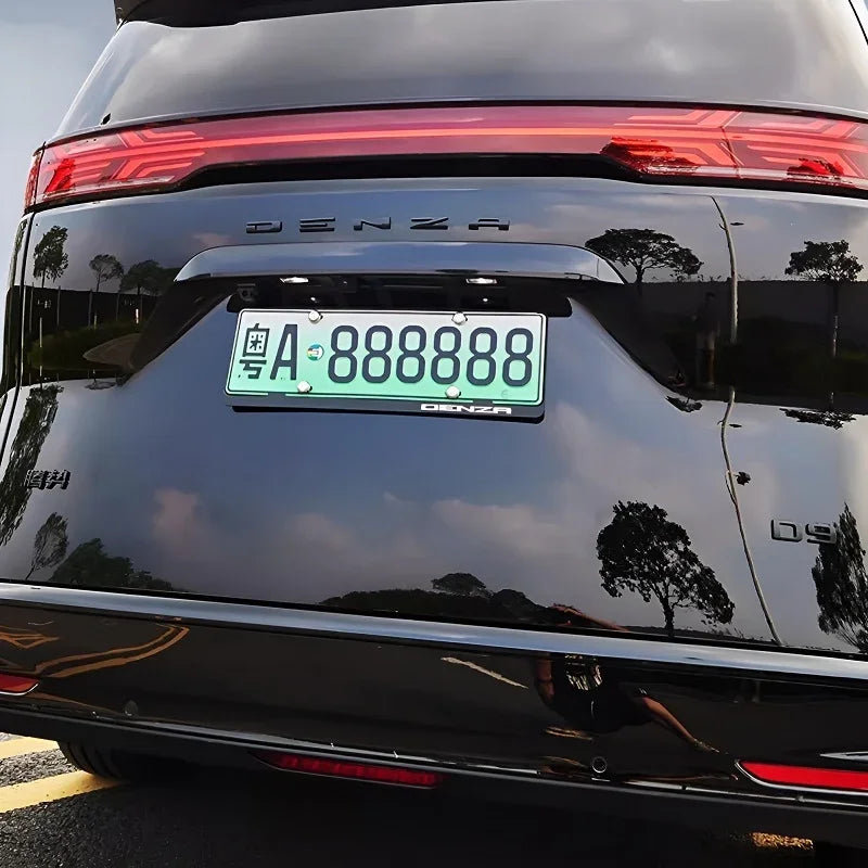 Rear view of a black Denza D9 luxury MPV featuring a sleek LED light bar and green license plate.