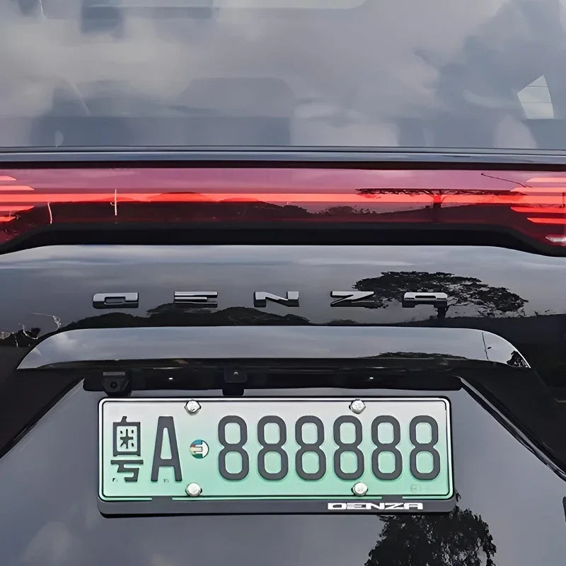Rear view of a black Denza car featuring a glowing red LED taillight and a green license plate.