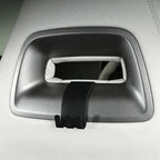 Black matte plastic grab handle hook accessory installed on a light grey car interior trim.