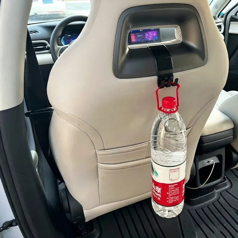 Black plastic car seat headrest hook holding a water bottle in a white leather interior.