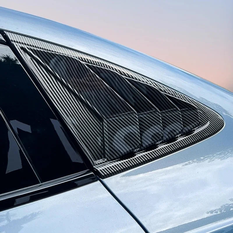 Black carbon fiber rear window louvers for car protection and aerodynamic styling.