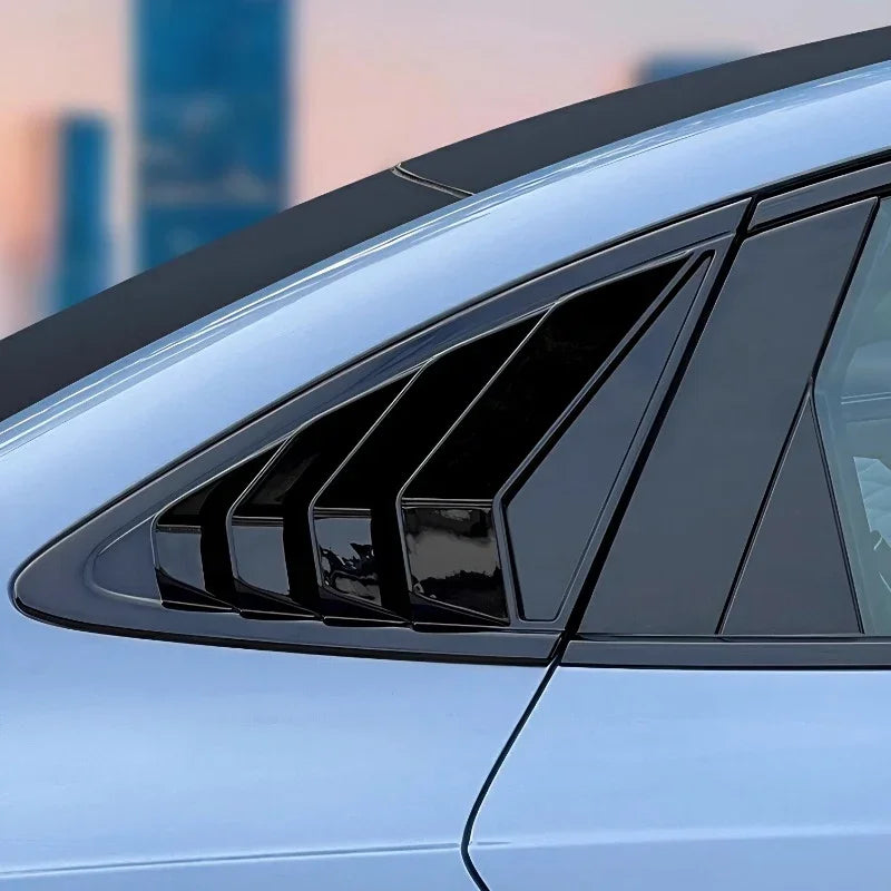 Glossy black window louvers for car side windows, featuring a sleek aerodynamic design.