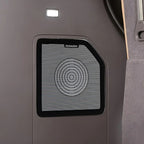 Black DVNAUDIO premium car door speaker with a concentric circle design on a grey interior panel.