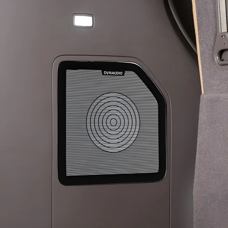Black DVNAUDIO premium car door speaker with a concentric circle design on a grey interior panel.