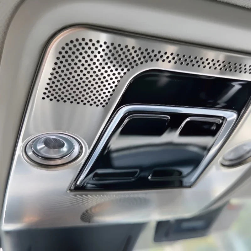 Close-up of a silver metallic interior ceiling console with perforated patterns and black accents.