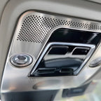 Close-up of a silver metallic interior ceiling console with perforated patterns and black accents.