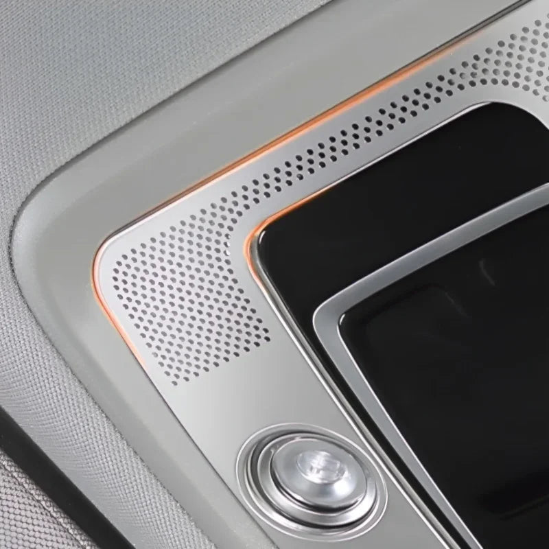 Silver metallic interior trim featuring a perforated texture and sleek orange ambient lighting.