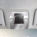 Close-up of a grey interior overhead console with integrated reading lights and sun visors.