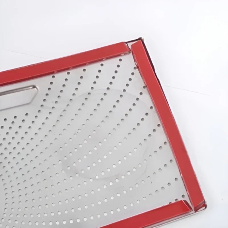 Red-trimmed perforated stainless steel tray with a sleek metallic finish.