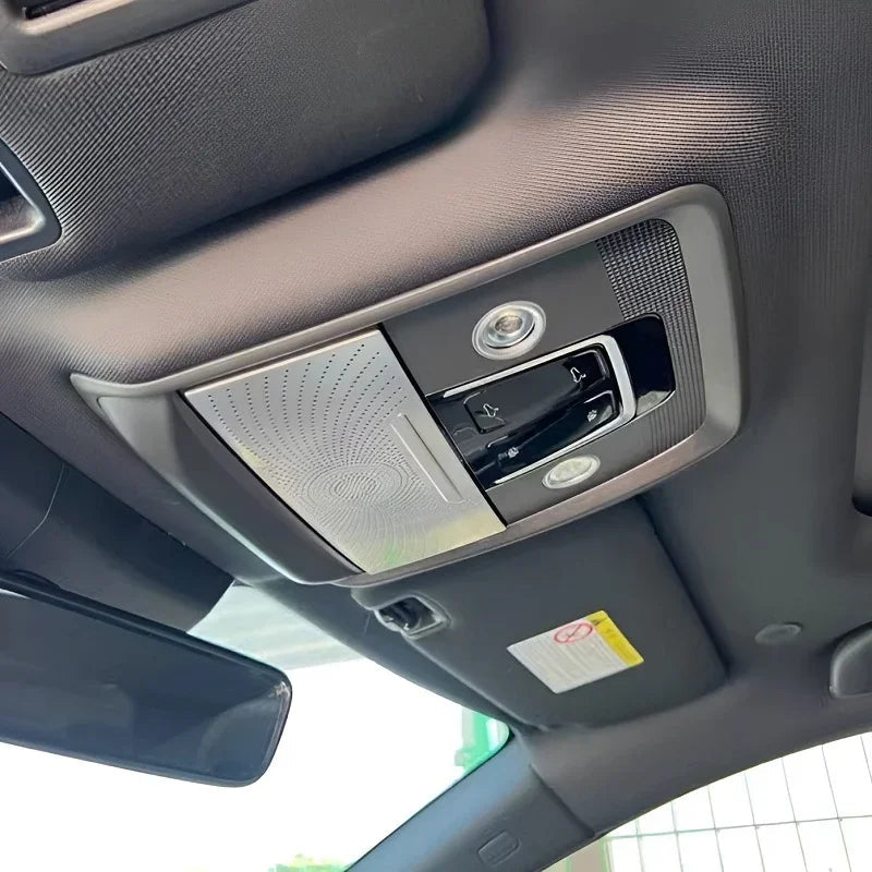 Interior view of a black fabric car ceiling featuring a silver sun visor and overhead console.