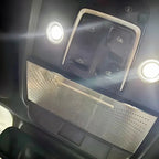 Silver perforated metal trim panel for car interior ceiling with integrated LED lights.