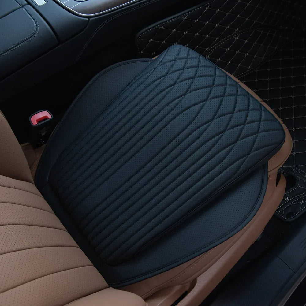 Black perforated leather car seat cushion with diamond quilted stitching on tan interior.