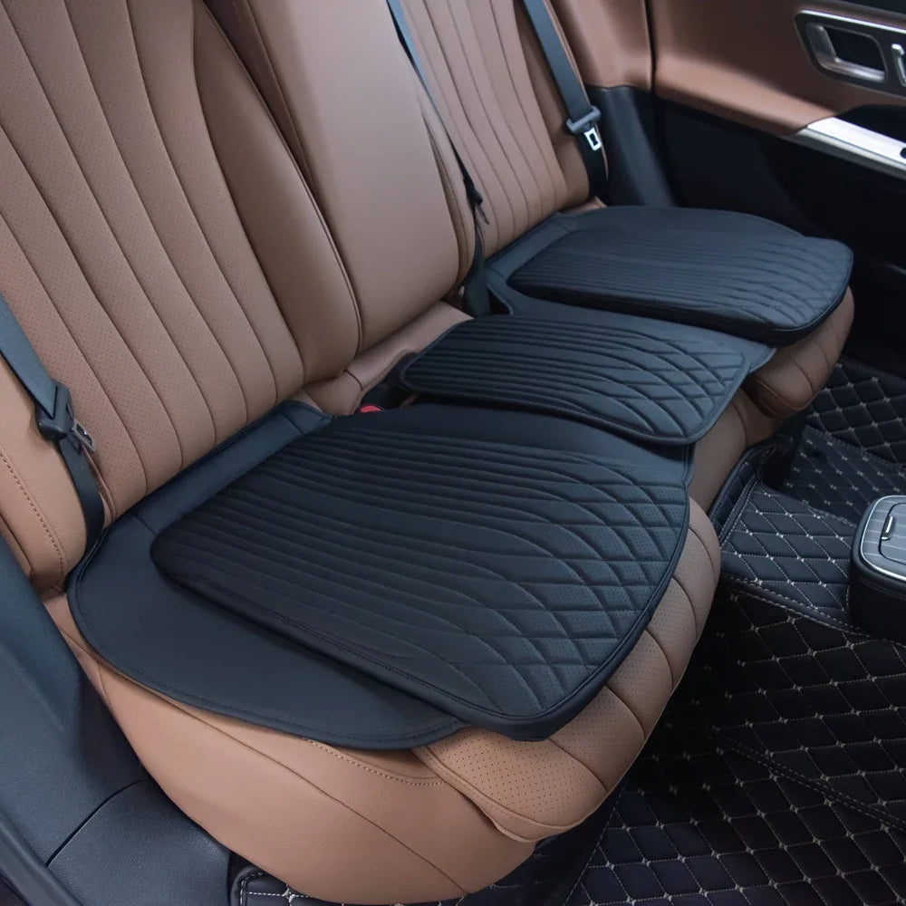 Black quilted leather car seat protectors installed on brown perforated leather interior seats.