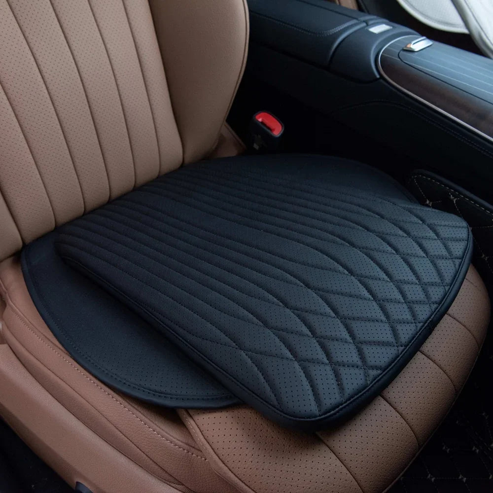 Black perforated leather car seat cushion with a quilted wavy pattern for enhanced comfort.