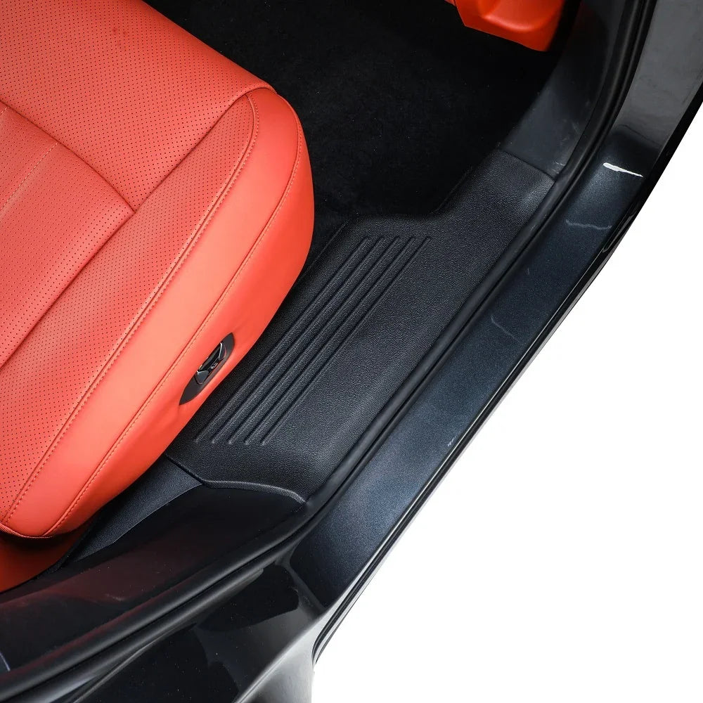 Black durable rubber door sill protector installed in a car with red leather seats