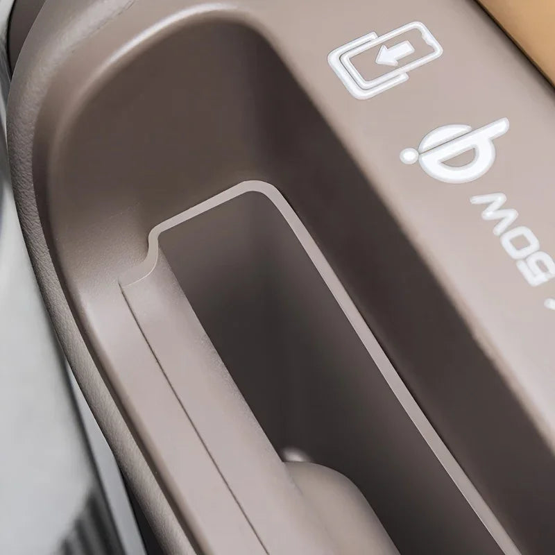 Close-up of a brown textured plastic interior car storage compartment with a white icon.