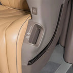 Close-up of a tan leather car seat back with a grey plastic storage pocket and charging port.