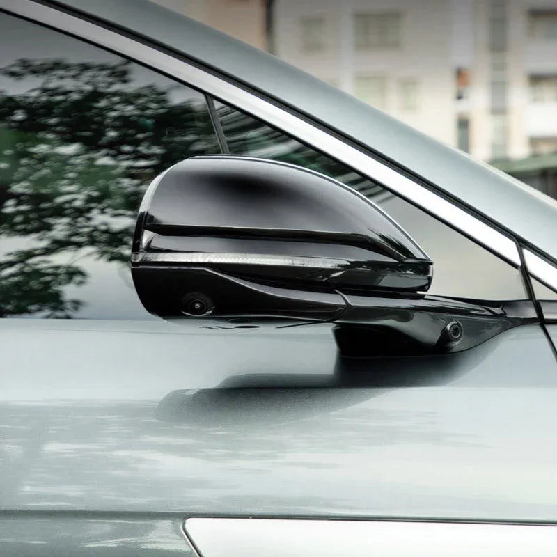 Glossy black aftermarket side mirror cover with integrated LED indicator for BYD car.
