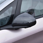 Close-up of a car side mirror cover featuring a sleek grey carbon fiber texture.
