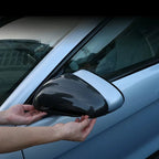 Carbon fiber pattern side mirror cover being applied to a light blue car.