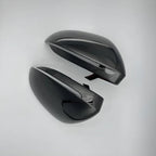 Glossy black aerodynamic car side mirror covers made of durable high-shine material.