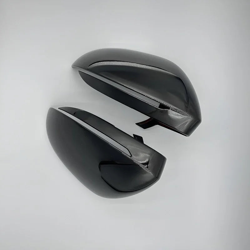 Glossy black aerodynamic car side mirror covers made of durable high-shine material.