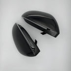 Glossy black aerodynamic car side mirror covers with a sleek, polished finish.